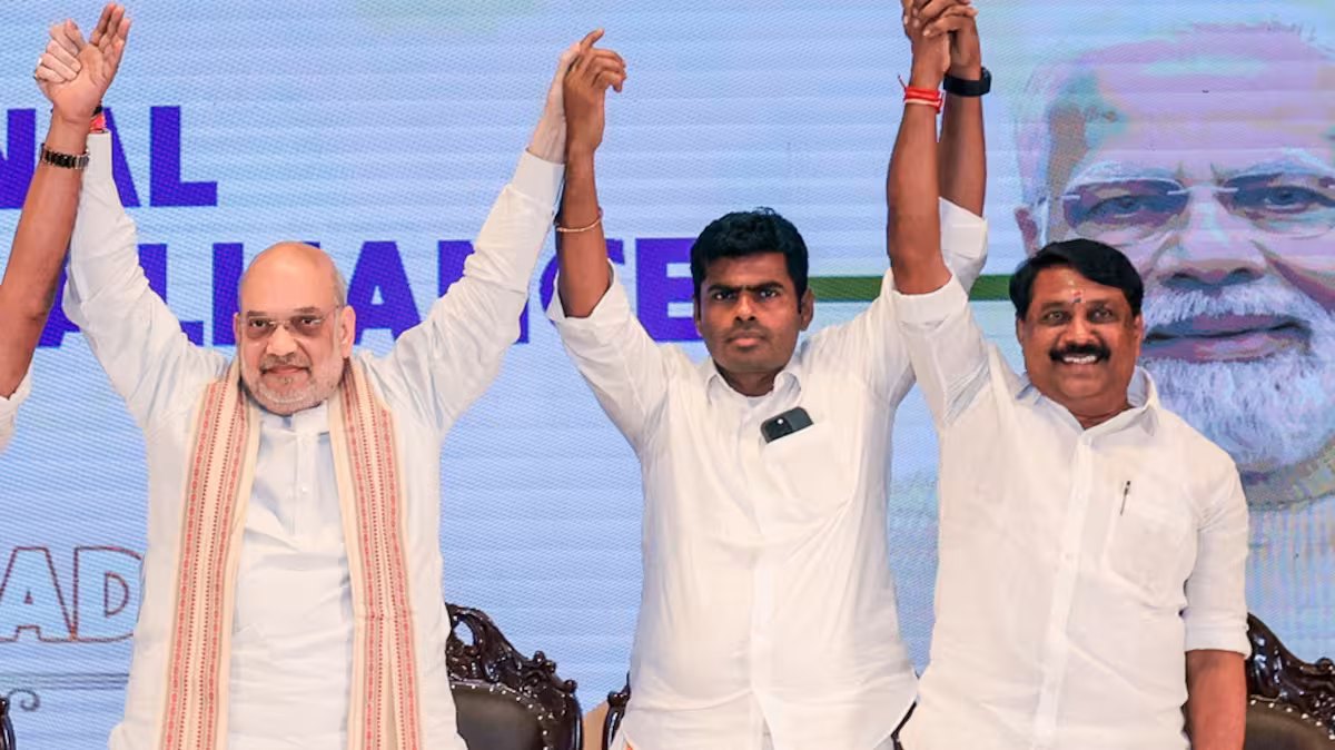 Nainar Nagendran on stage with Union Home Minister Amit Shah and K. Annamalai, their hands raised together at an alliance event