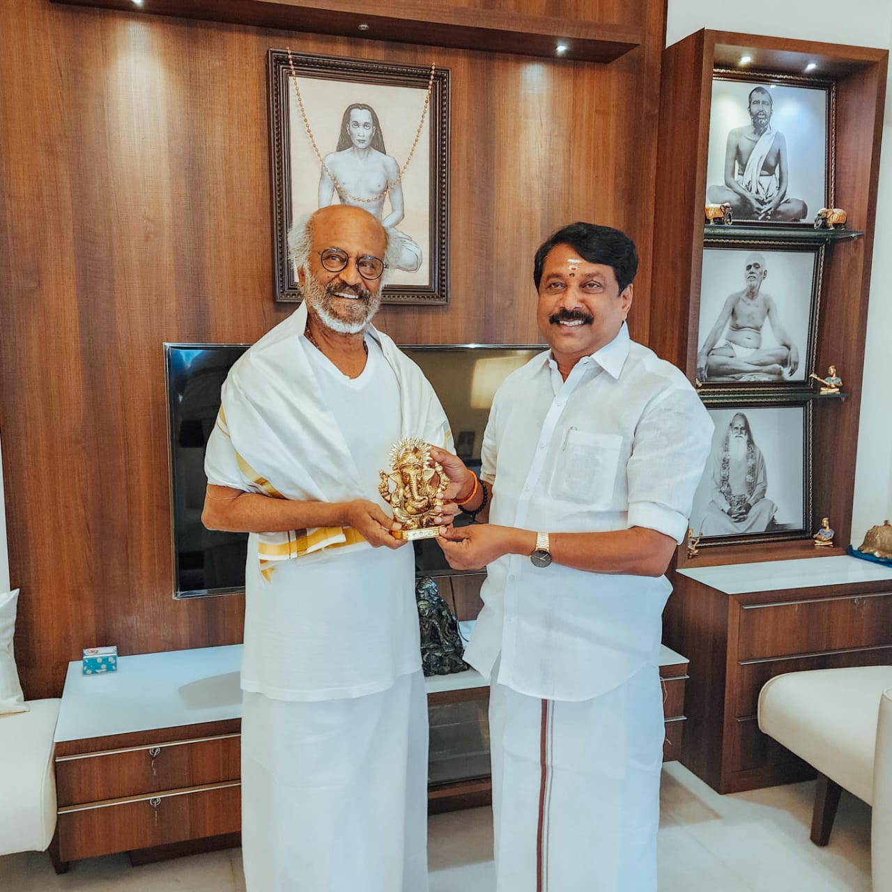 Nainar Nagendran and the actor Rajinikanth standing together indoors, jointly holding a small golden statuette