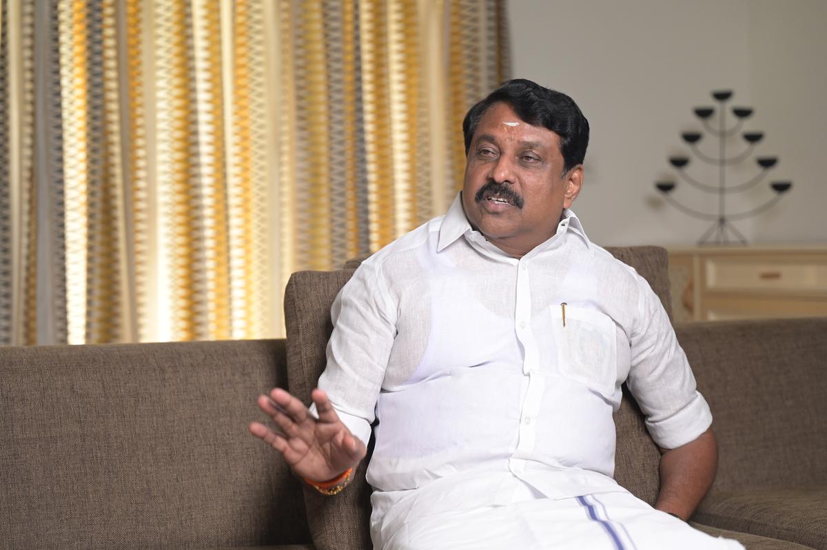 Nainar Nagendran seated on a sofa in conversation, gesturing while speaking during an interview